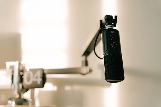 A sleek professional microphone on a boom arm in a minimalist studio. What podcast SEO pricing models really mean explained
