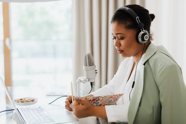 A focused woman recording a podcast indoors with headphones and microphone. Why podcast SEO key metrics need documented sources, not dashboard guesses