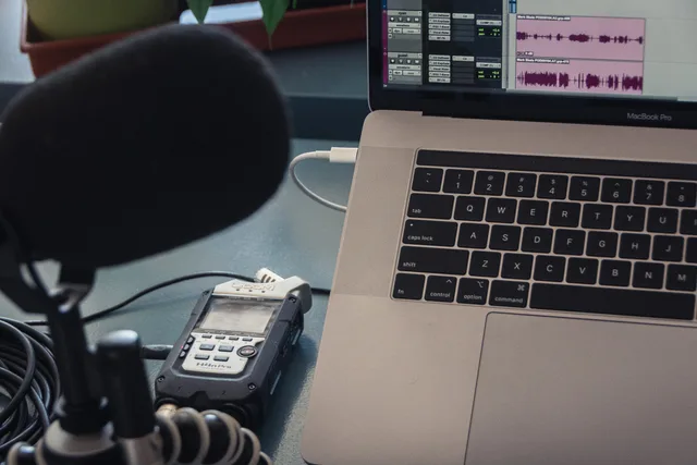 Microphone and laptop setup for audio recording in a studio environment. Podcast SEO service standards in England explained for operations teams