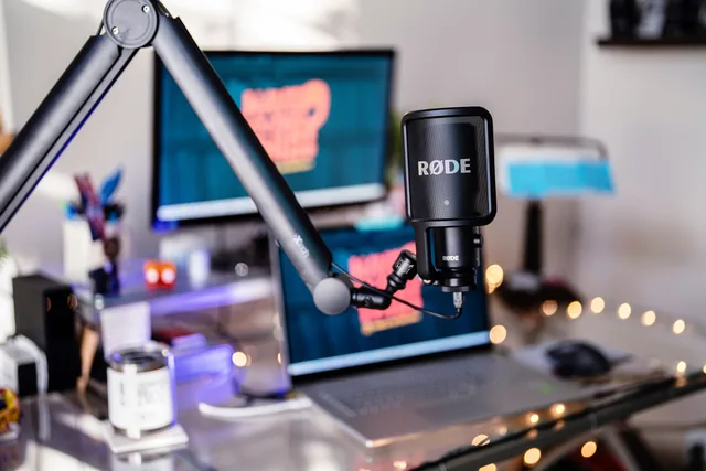 Close-up of a modern podcast studio featuring a RØDE microphone and digital workspace, ideal for content creators. A four-stage plan for podcast SEO tool implementation