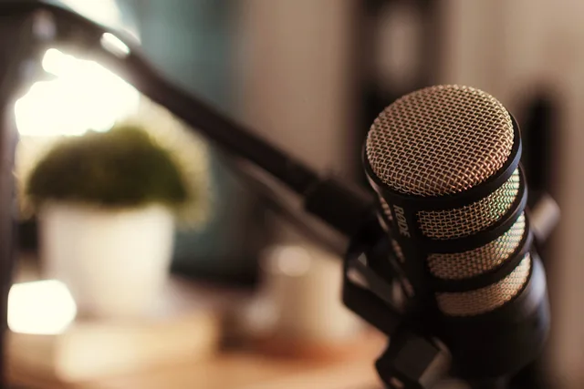 A professional microphone setup for podcasting with blurred background and cozy lighting. Podcast SEO rules and ethics: a UK compliance checklist and risk verdict